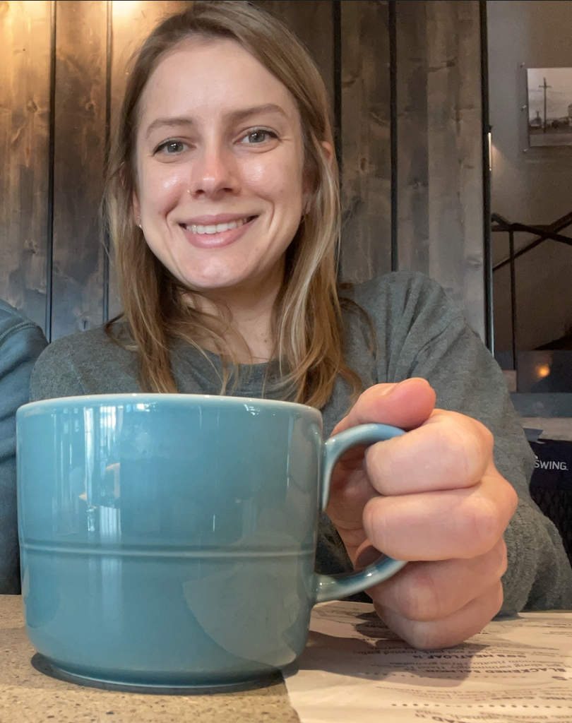 Ashley holding a cup of coffee